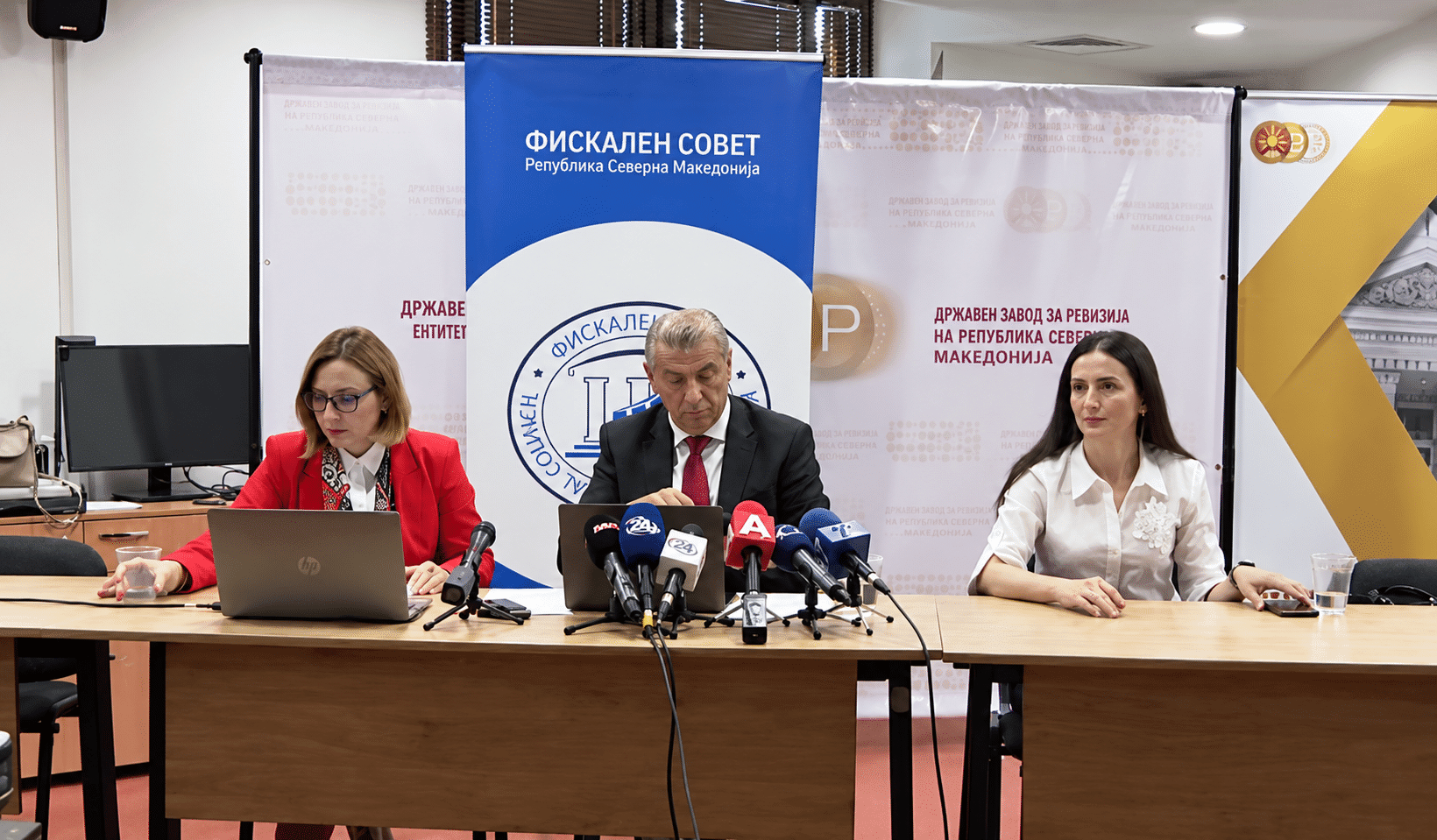 Press conference with microphones and laptops